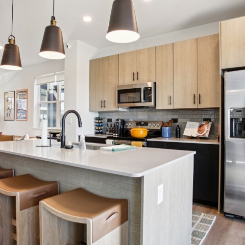 wood cabinets and quartz countertops in an open kitchen